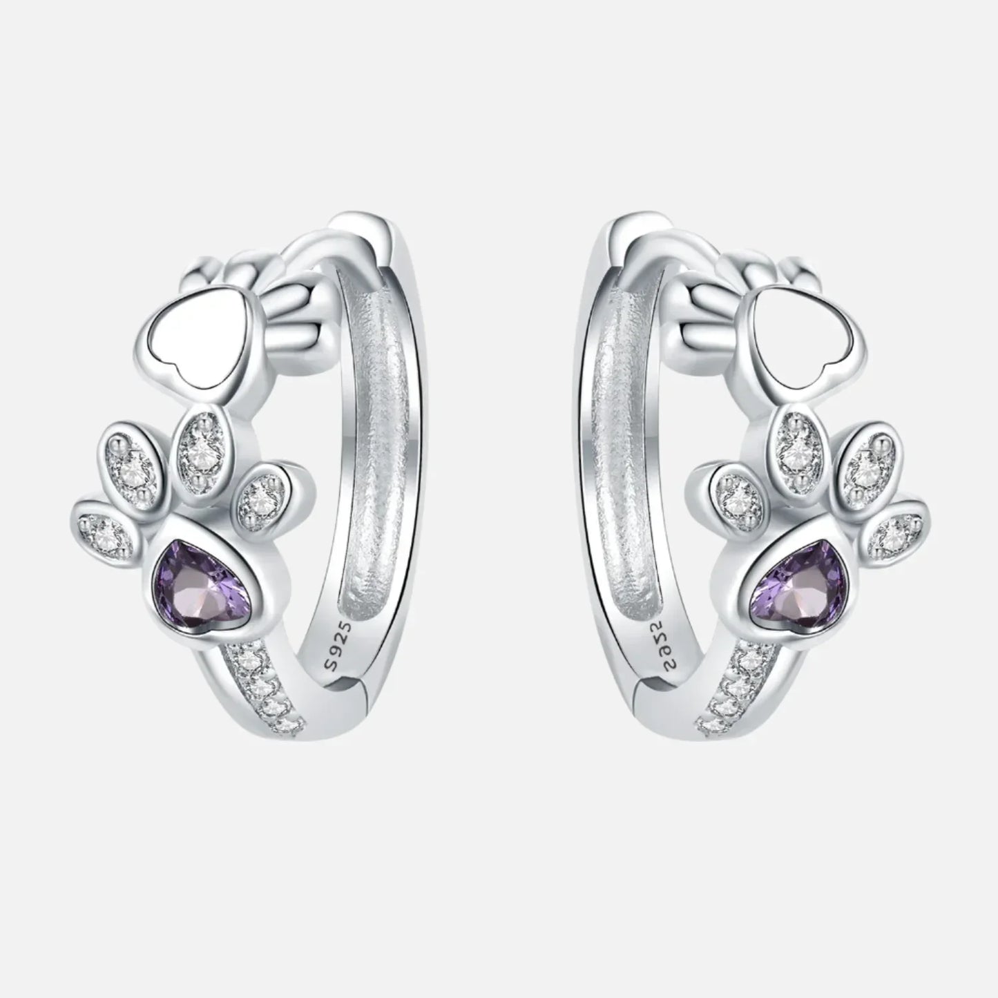 Oorbellen met pootafdruk in zilver met zirkonia en een hartvormige edelsteen.