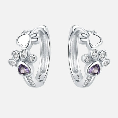 Oorbellen met pootafdruk in zilver met zirkonia en een hartvormige edelsteen.