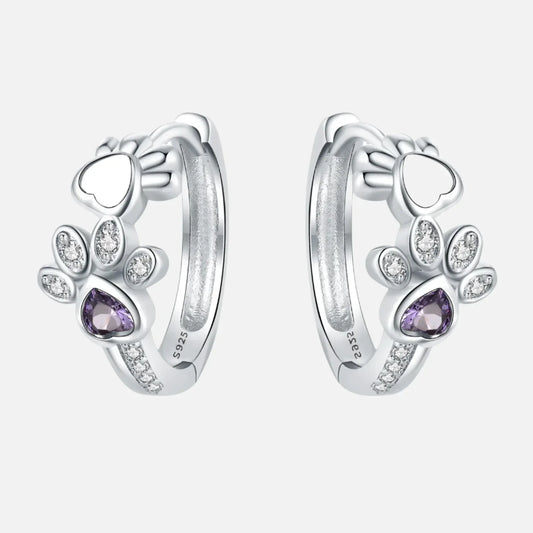 Oorbellen met pootafdruk in zilver met zirkonia en een hartvormige edelsteen.